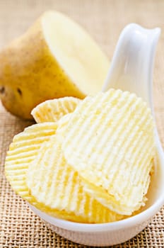 chips and peeled potato on a sack background.