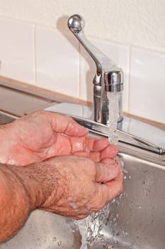 Hand washing under pure clean running water from the faucet.