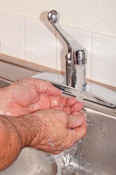Hand washing under pure clean running water from the faucet.