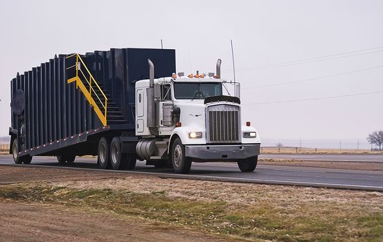 Semi-truck hauling a drill location tank.