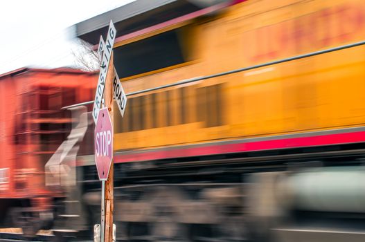 Waiting at a railroad crossing while a fast freight train passes by.