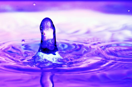 Stop action photo of water drop with violet reflection