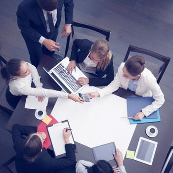 Business workplace with people, cup of coffee, digital tablet, smartphone, papers and various office objects on table