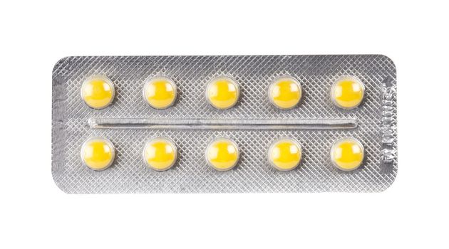 yellow pills in blister pack on white background