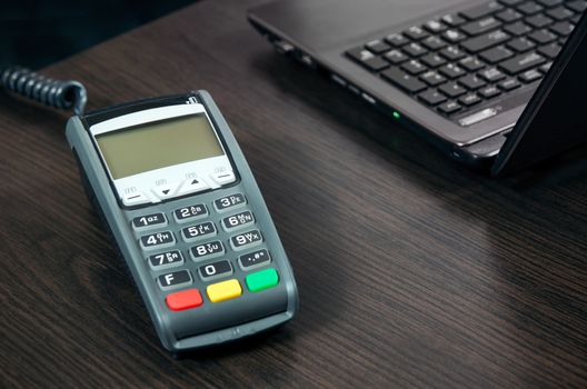 Payment terminal in the office. Laptop in the background