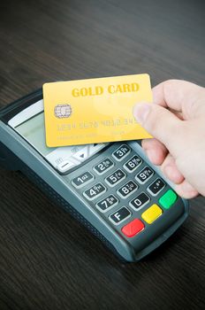 Man pays a gold card in payment terminal