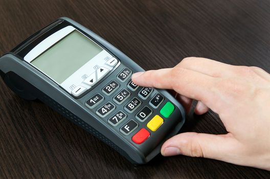 Man hand using payment terminal in shop