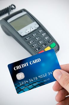 Hand holding credit card. Payment terminal in background