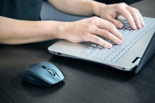 Man using laptop with white keyboard. Working in office