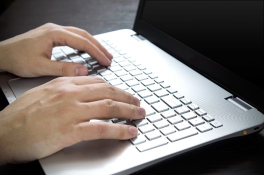 Man using laptop with white keyboard. Working in office