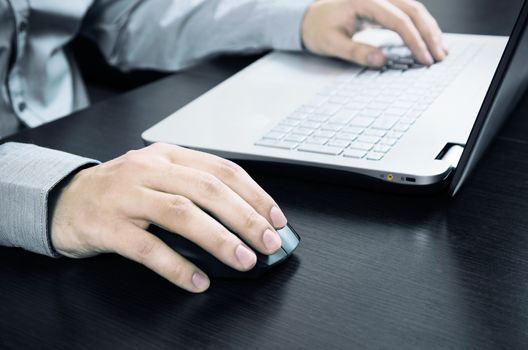 Man using laptop with white keyboard. Working in office