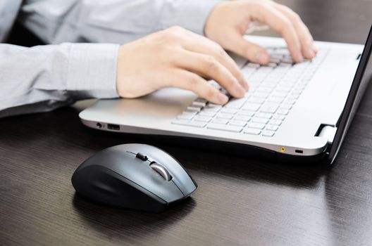 Man using laptop with white keyboard. Working in office