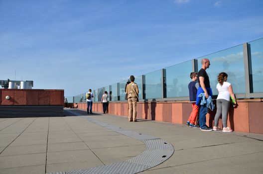 Antwerp, Belgium - May 10, 2015: People visit rooftop of Museum aan de Stroom (MAS) on May 10, 2015. in Antwerp, Belgium. The roof affords a 360° panoramic view of the city, river and port.