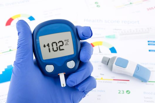 Doctor making blood sugar test. Hands with gloves on medical background 