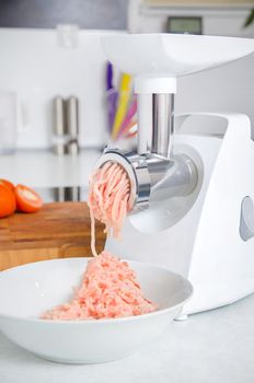 Grinder with minced meat in modern kitchen