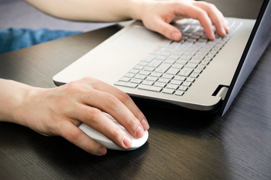 Man working in office. Laptop with white keyboard and white mouse