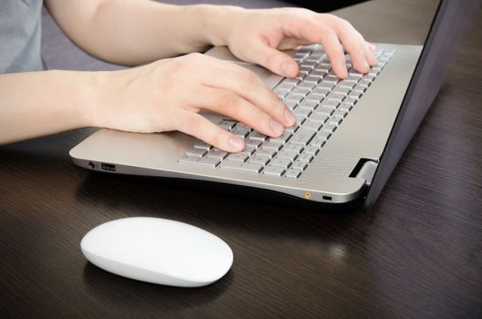 Man working in office. Laptop with white keyboard and white mouse