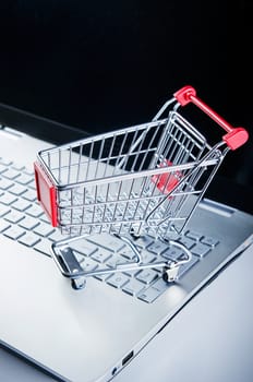 Internet shopping concept. Basket on laptop keyboard