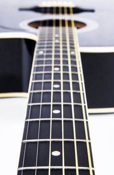 Close up of acoustic guitar strings. Instrument lying on a white background