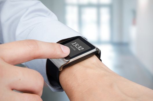 Businessman checking time on modern smart watch. Office in background