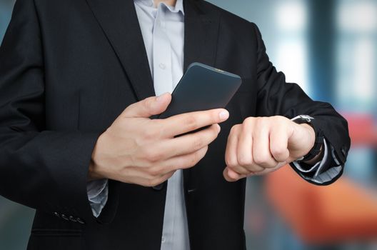 Businessman with smartphone and smartwatch working in office