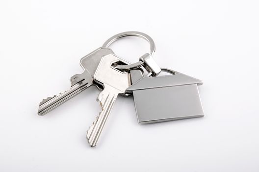 Keys and house chrome pendant with home shape isolated on white background