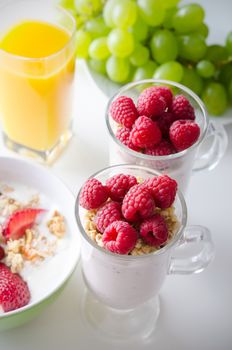 Glass of dessert with fresh berries, muesli and yoghurt on table