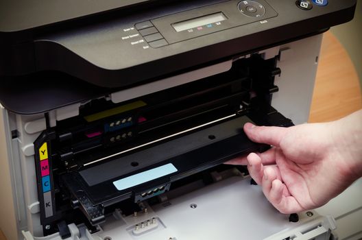 Close up of man puts toner in the printer