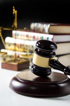 Judge gavel and scale in court. Library with lot of books in background