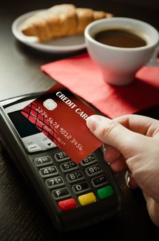 Man using payment terminal with NFC contactless technology in cafeteria