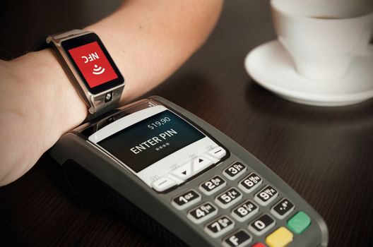 Man making payment through smartwatch via NFC contactless technology