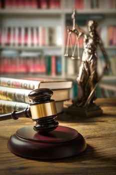 Law concept with gavel and Themis in background. Composition in court library