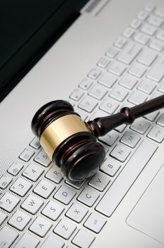Wooden judge hammer on laptop computer white keyboard
