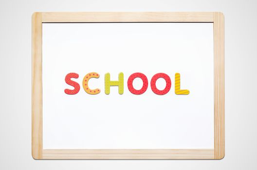 Hand put the word School on magnetic board. Colorful alphabet kit