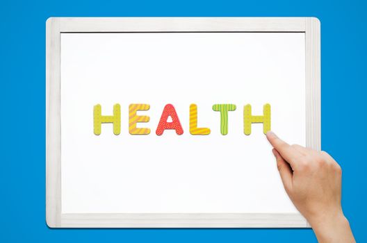 Hands put the word Health with magnetic letters. Colorful alphabet kit