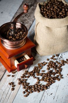 Coffee grinder with roasted beans. Vintage mill composition