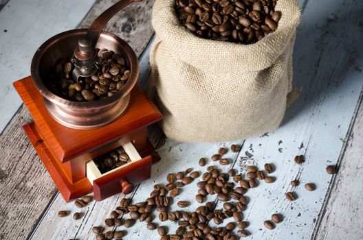 Coffee grinder with roasted beans. Vintage mill composition