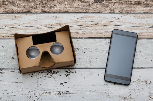 Virtual reality cardboard glasses. Easy way to watch movies in 3D. Shoot on wooden background.