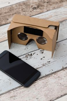 Virtual reality cardboard glasses. Easy way to watch movies in 3D. Shoot on wooden background.