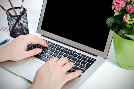 Man working with modern laptop in office. Hands typing on keyboard