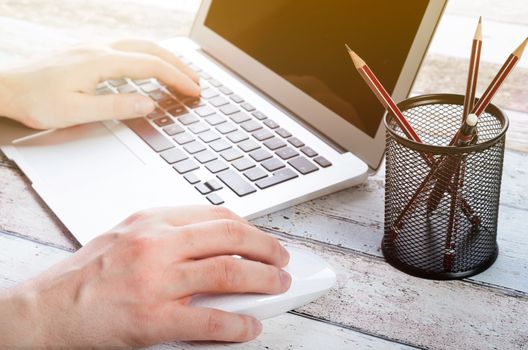 Man working with modern laptop in office. Hands typing on keyboard