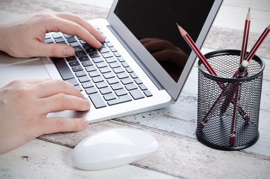 Man working with modern laptop in office. Hands typing on keyboard