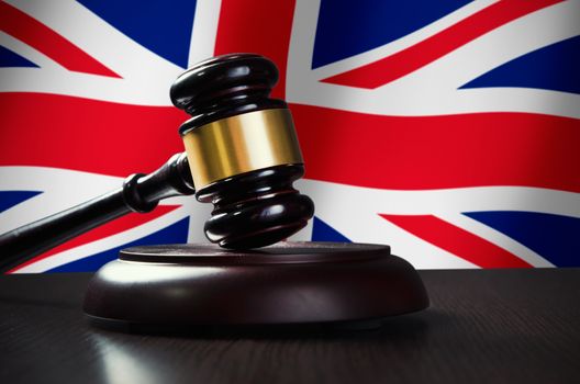 Wooden gavel with United Kingdom flag in background. Justice and law symbol