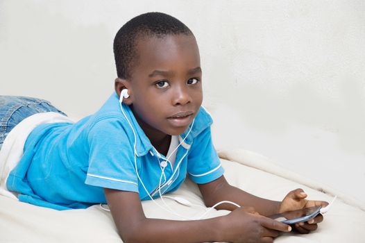 The child listens to music  from mobile phone of his father