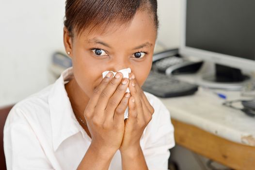 This young woman has clogged her nostrils with her  handkerchief because they flow.