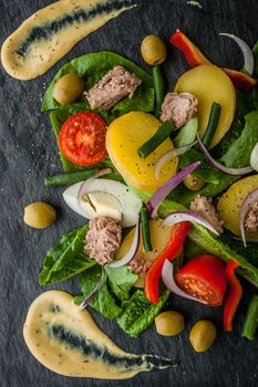 Nicoise salad with sauce on the black stone  vertical