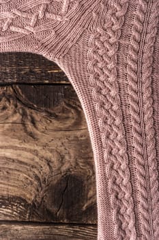 Pink figured sweater on the wooden board