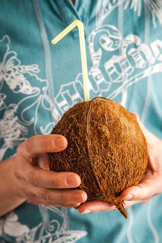 Coconut with straw in the hands