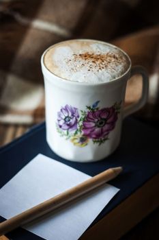 Cup of cappuccino with book , empty paper and pencil vertical