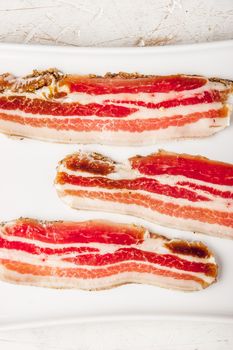 Streaky bacon with  on the white plate vertical